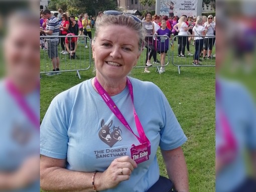 Margaret O'Mullane holding mini marathon medal.